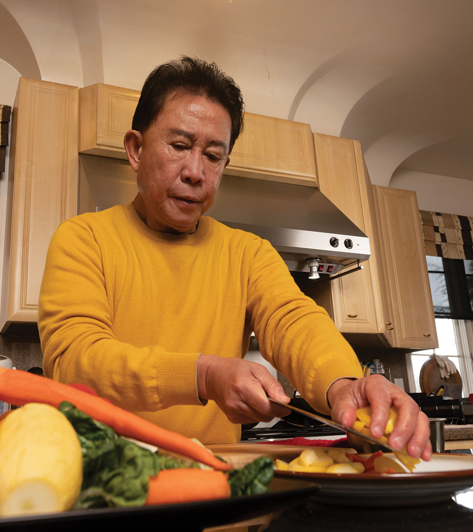 Martin Yan slices vegetables in his home kitchen