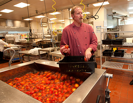 Chef Bob explains to visitors how the Segundo Culinary Center processes tomatoes in bulk, to make sauce, in this photo from 2014.