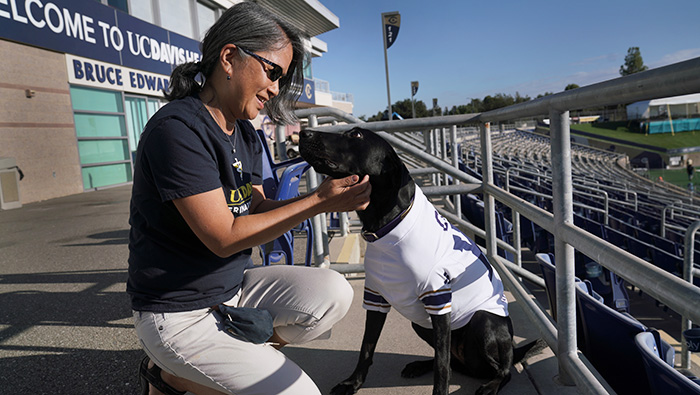 Alumna Lisa Tell with dog Cori at the stadium