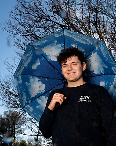 Colin McCarthy holds an umbrella outside