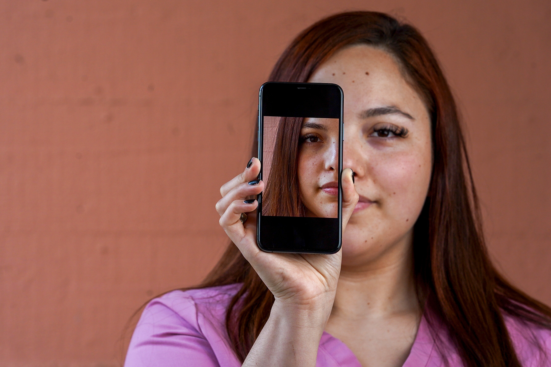 Natalie Torres holds an iPhone in front of her face