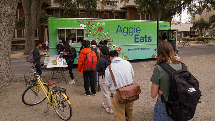 Students line up and use their smartphones to order on the first day of full service of the AggieEats food truck, believed to be the first in the nation to offer free and pay-what-you-want meals on a college campus. (Karin Higgins/UC Davis)