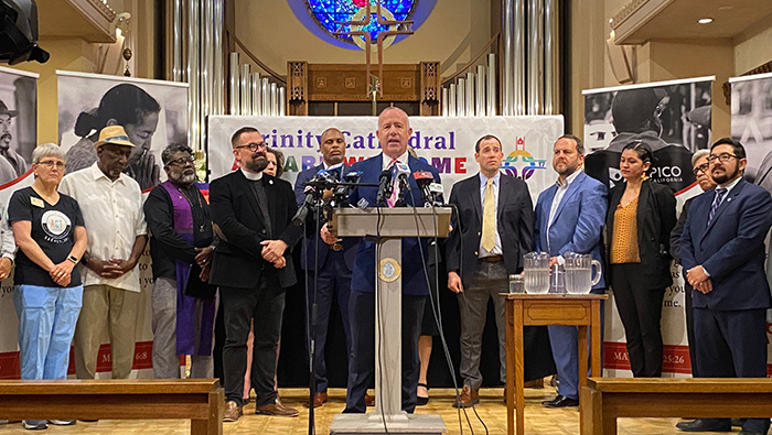 Community leaders address the media in a church