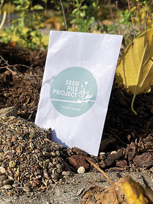 A packet of seeds sits on the ground ready to be opened and spread
