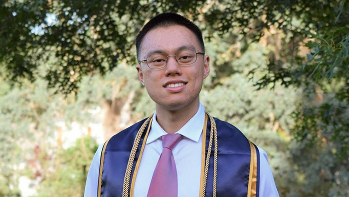UC Davis grad in graduation ribbons
