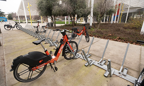 Electric bikes and scooters parked in racks