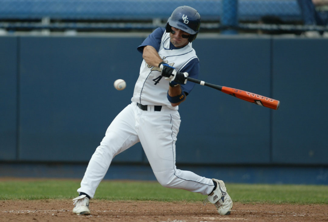An Aggie baseball player swings the bat at a near ball.