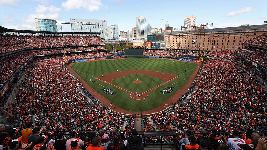 Wide-angle photo of a sold-out game at Oriole Park at Camden Yards. The view is from behind home plate, high up in the stands. The left and right field stands are seen.